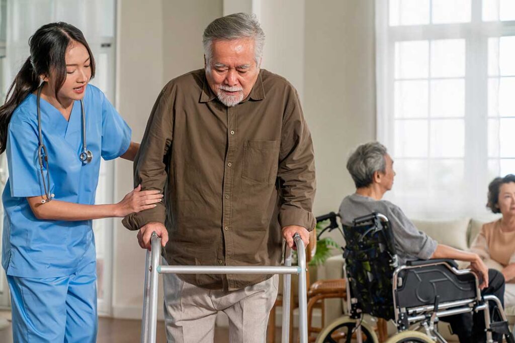 Older adults play a table game together in a bright assisted living community room.