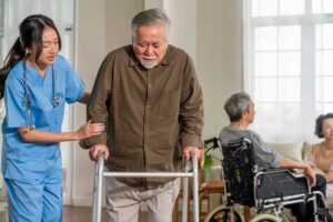 Older adults play a table game together in a bright assisted living community room.