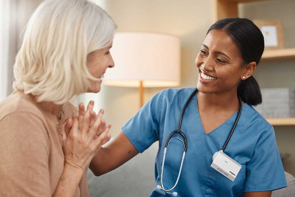Older adult and family member touring a bright assisted living apartment with a staff guide nearby.